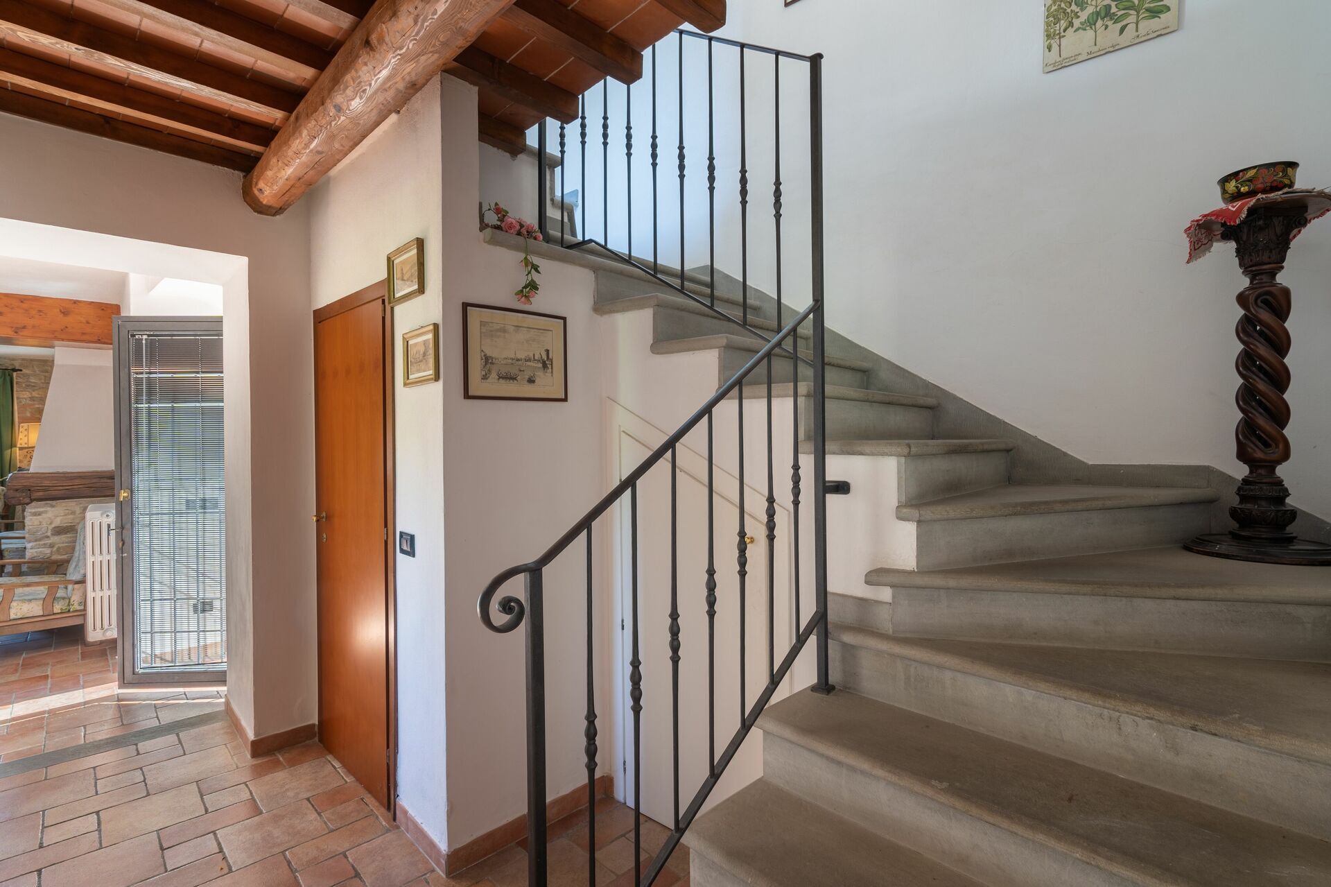 A staircase with a metal railing, a wooden door, and a framed picture on the wall.