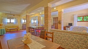Un amplio espacio de sala con una mesa de comedor, sofás y una cocina al fondo.