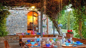 An outdoor dining area with stone walls, wooden tables, and benches. - Villa Sant' Angelo - Villa with private pool (Poppi)