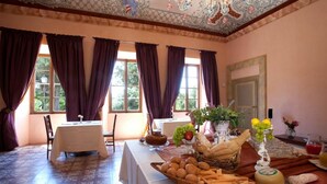 A dining room with a table set for a meal, featuring bread, cheese, and a fruit basket. - Villa Gubbio - Luxury Villa Rental with private swimming pool in Gubbio, Umbria (Gubbio)