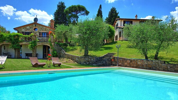 A swimming pool with a stone wall and steps leading to a house with a stone facade and a circular window. - Villa Ulivi - Holiday Country Villa in Lucignano, Valdichiana, Tuscany (Lucignano)