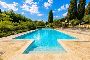 A rectangular swimming pool with clear blue water, surrounded by a tiled deck.
