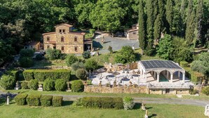 A stone building with a courtyard, surrounded by lush greenery and a hillside. - Adamo ed Eva - Holiday Rental with swimming pool on the Tuscan Coastline (Monteverdi Marittimo)
