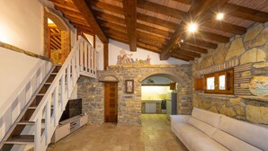 A spacious living area with a stone fireplace, a staircase, and a cozy seating area. - Adamo ed Eva - Holiday Rental with swimming pool on the Tuscan Coastline (Monteverdi Marittimo)
