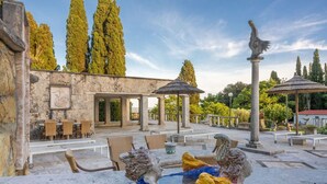 An outdoor seating area with stone tables and chairs, a stone fountain, and a pergola. - Adamo ed Eva - Holiday Rental with swimming pool on the Tuscan Coastline (Monteverdi Marittimo)