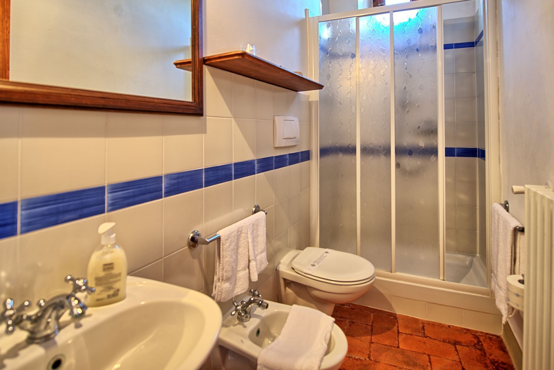 Ein Badezimmer mit Waschbecken, Bidet, Toilette und einer Duschkabine aus Glas.