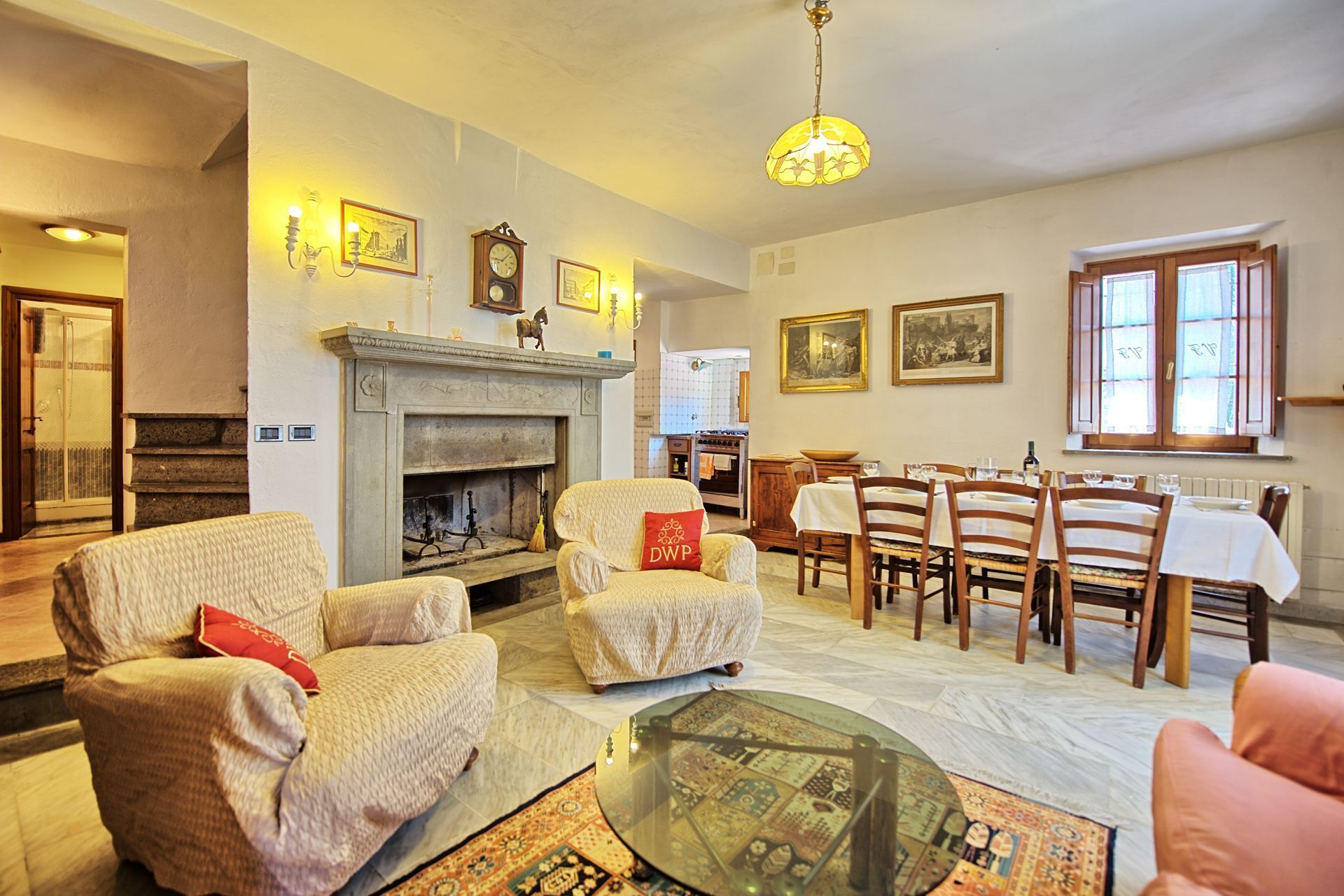 A cozy living room with a fireplace, comfortable seating, and a dining area with a table set for four.