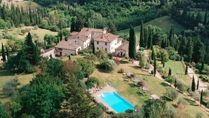 Une grande villa entourée d’une végétation luxuriante et dotée d’une piscine.