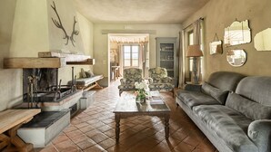 A cozy living room with a fireplace, comfortable seating, and a view of the outdoors. - Villa Danilo - Luxury Holiday Villa with private swimming pool in San Casciano dei Bagni, Orcia ... (San Casciano Dei Bagni)