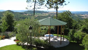 A gazebo with a green roof, surrounded by lush greenery and a scenic view of rolling hills. - Dante 5 - Apartment with swimming pool (Volterra)