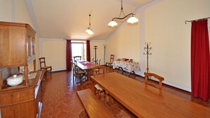 A spacious dining area with a long wooden table, multiple chairs, and a chandelier. - Dante 3 - Apartment with swimming pool (Volterra)
