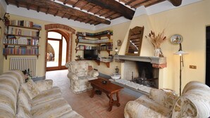 A cozy living room with a fireplace, bookshelves, and comfortable seating.