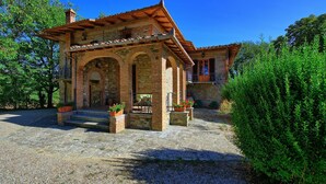 A rustic stone building with a tiled roof, arched doorways, and a small balcony. - Casale Ambra - Country house with private pool (Ambra)