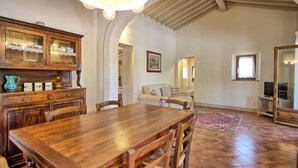 Ein Essbereich mit Holztisch und Stühlen, einem Buffet und einer Pendelleuchte.