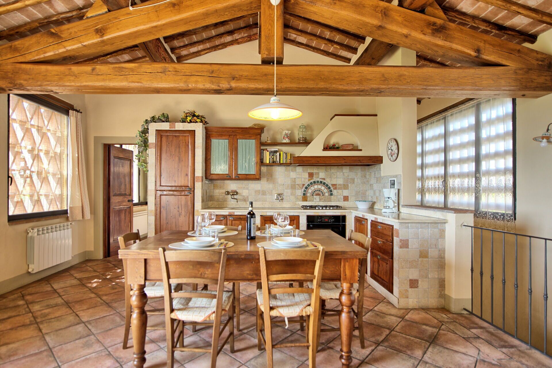 Una cocina amplia con una isla grande, armarios de madera y un techo rústico.