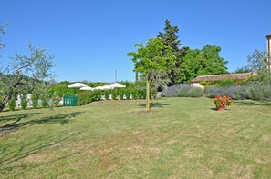 A well-maintained garden with a lawn, a tree, and a flower bed.