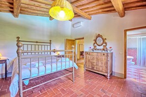 A bedroom with a wooden bed, a dresser, and a mirror.