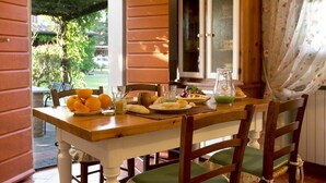 A dining table with chairs, a cabinet, and a window with curtains.
