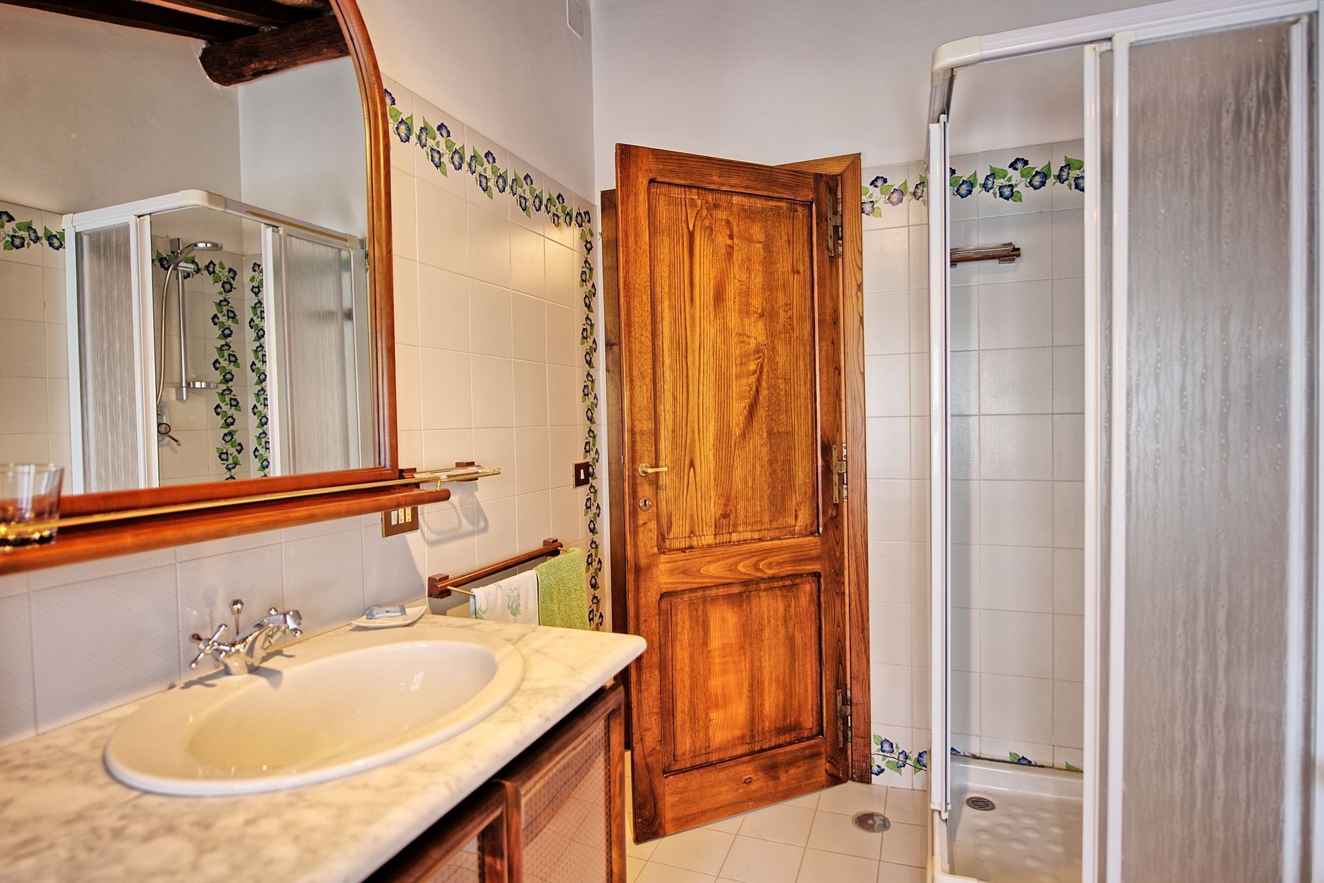 Une salle de bain avec une porte en bois, un lavabo et une douche.