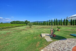 Surrounded by lush greenery, this serene outdoor space offers a tranquil escape with a stone pathway leading to a seating area.