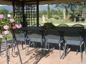 Relax on the patio with a table and comfortable chairs surrounded by lush greenery and vibrant flowers.