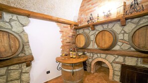 A wine cellar with stone walls, wooden barrels, and a brick fireplace. - I Gigli di Bolsena - Exclusive Villa Rental in Montefiascone, Lake Bolsena (Montefiascone)