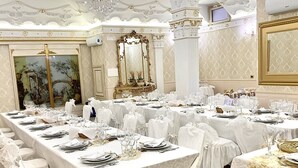 A banquet hall with long tables set for a formal event, featuring ornate columns and a large mirror. - I Gigli di Bolsena - Exclusive Villa Rental in Montefiascone, Lake Bolsena (Montefiascone)