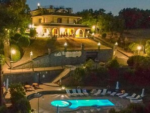 Un edifici amb piscina, zona de seients exteriors i escala que condueix al nivell superior.