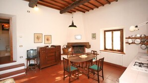 Un comedor con mesa y sillas de madera, una chimenea y un ventanal con vistas.