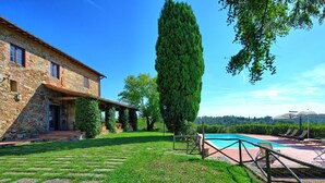 A stone house with a swimming pool, surrounded by a well-maintained lawn and a tall tree. - Il Frantoio - Villa with private pool (Montelupo Fiorentino)