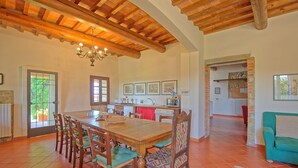 A spacious dining area with a wooden table and chairs, a kitchen with a tiled backsplash, and a living area with a sofa and a patterned rug. - Il Frantoio - Villa with private pool (Montelupo Fiorentino)