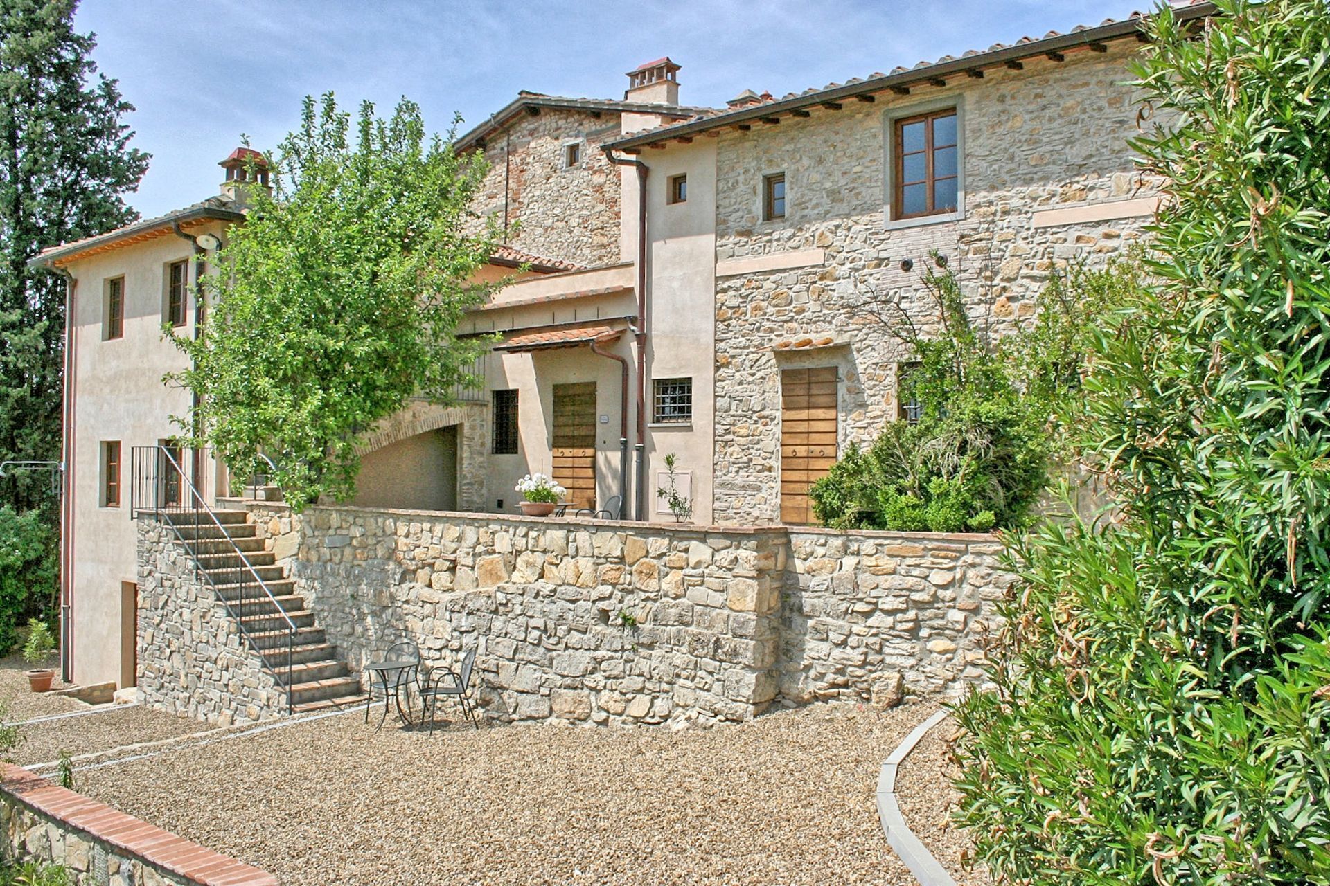 Un bâtiment en pierre avec un escalier menant à un porche abrité.