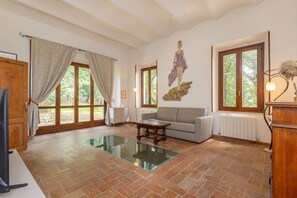 A spacious living room with a glass coffee table, a sofa, and a fireplace.