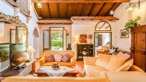 A cozy living room with a wooden ceiling, a television, a sofa, and a coffee table. - Vacation Home in Pilarciano with 4 bedrooms sleeps 7 (Pilarciano)