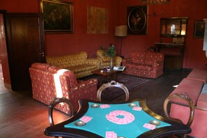 Una sala de estar con sofá, sillones, una mesa de centro y una mesa de comedor con sillas.