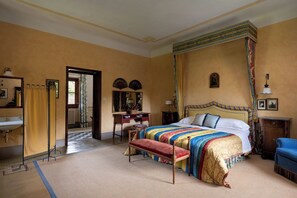 Un dormitorio con una cama grande, un banco, un escritorio y una silla.