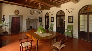 Un comedor espacioso con una mesa y sillas de madera, chimenea y decoración mural.