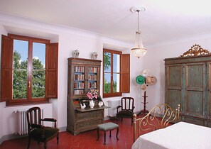 Experience a classic ambiance with a traditional bookcase, chandelier, and comfortable bed.