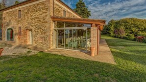 Un edificio de piedra con puerta de cristal y un porche cubierto.