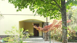 A building with a yellow facade, a stone entrance, and a tree with red leaves in the foreground. - Wonderful private villa for 4 guests with WIFI, TV, pets allowed and panoramic view (Porretta Terme)