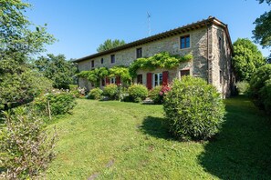 A stone house with a garden, a red door, and a chimney. - Stunning private villa with private pool, WIFI, TV, patio, pets allowed and panoramic view (Rupecanina)
