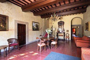 A dining area with a wooden table and chairs, a chandelier, and a staircase leading to an upper level.