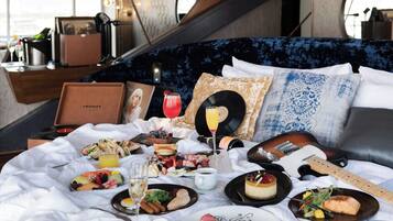A bed with a variety of food items, drinks, and a guitar, suggesting a musical theme.