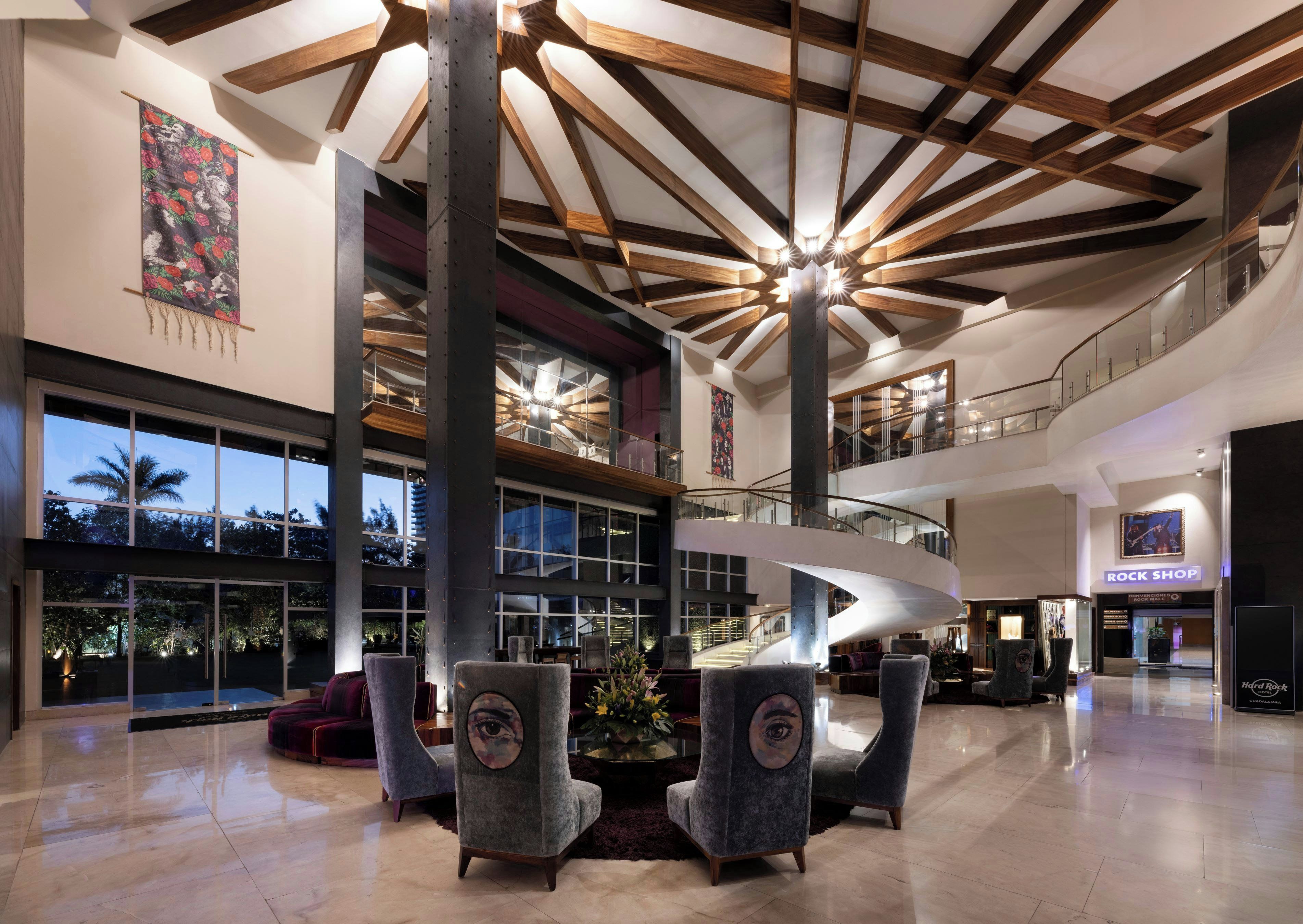 A spacious lobby with a high ceiling, a central staircase, and a rock shop.