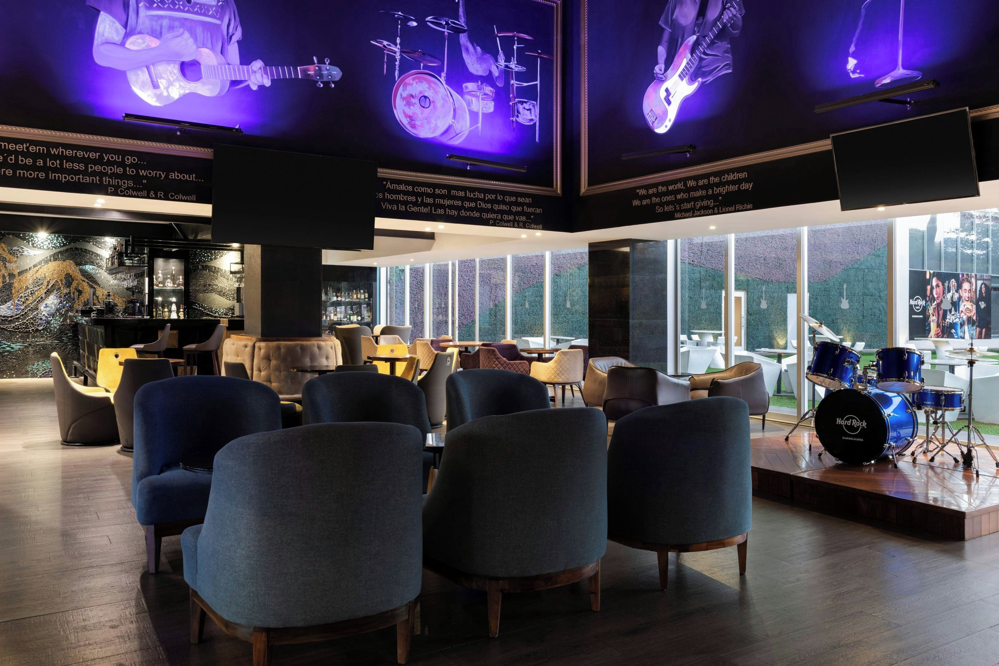 A lounge area with seating and a stage with musical instruments.