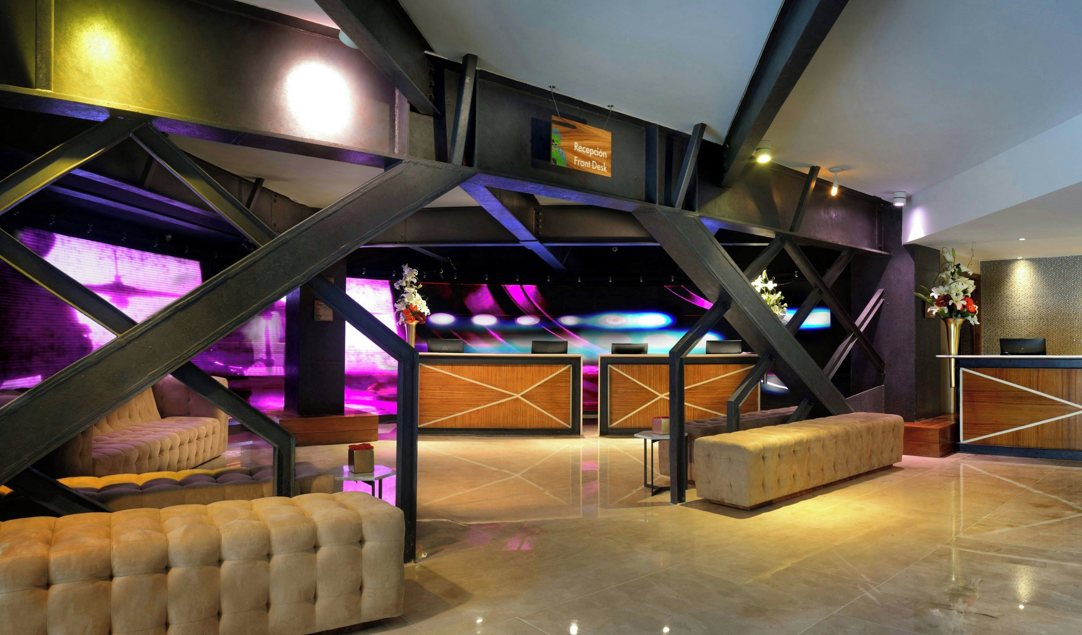 A reception area with a reception desk, seating, and a stage with colorful lighting.