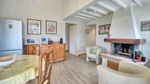 Ein gemütliches Wohnzimmer mit Kamin, Holzmöbeln und einem Essbereich.