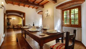 A dining area with a wooden table set for four, a bench, and a window with a view of greenery. - Beautiful private villa for 12 guests with WIFI, private pool, pets allowed and panoramic view (Ostina)