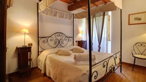 A four-poster bed with a canopy, wooden floor, two bedside tables with lamps, and a chair. - Beautiful private villa for 12 guests with WIFI, private pool, pets allowed and panoramic view (Ostina)