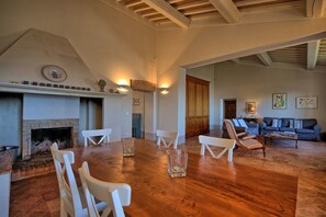 Un salon spacieux doté d’une cheminée, de parquet et d’un coin salon avec un canapé et des fauteuils.